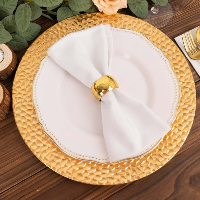 Elegant white napkin with a gold ring on a decorative gold charger plate.