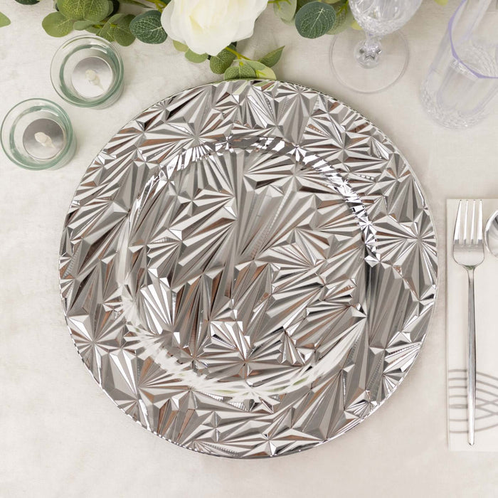 Decorative silver charger plate with geometric design on a dining table setting.