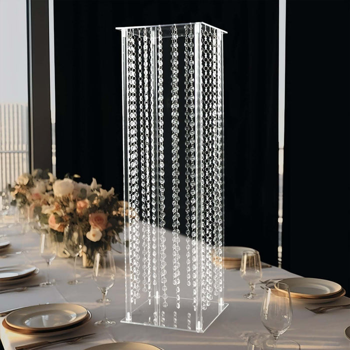 Elegant acrylic display stand with hanging crystals for event decor.