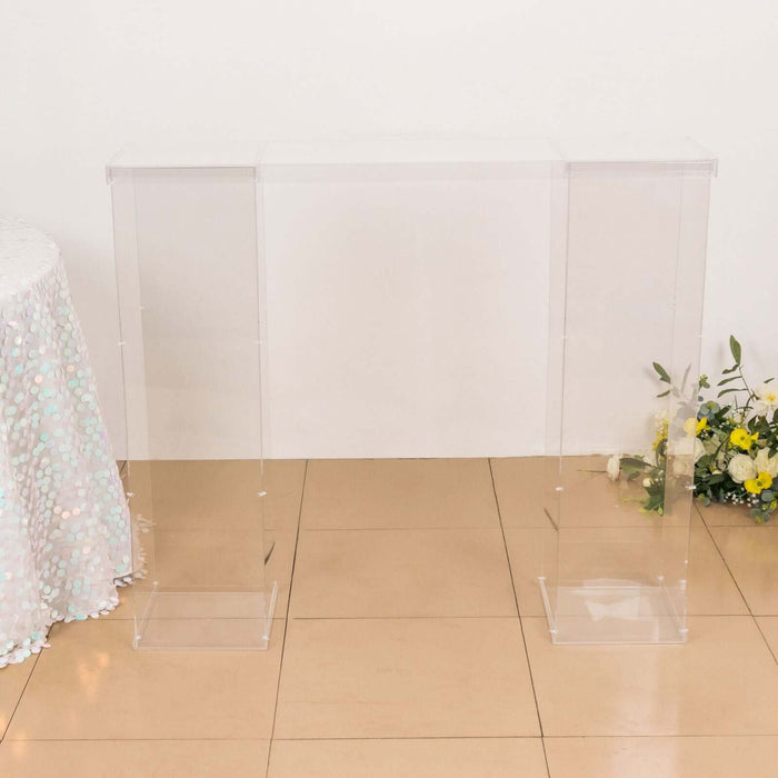 Clear acrylic console table on a plain backdrop.