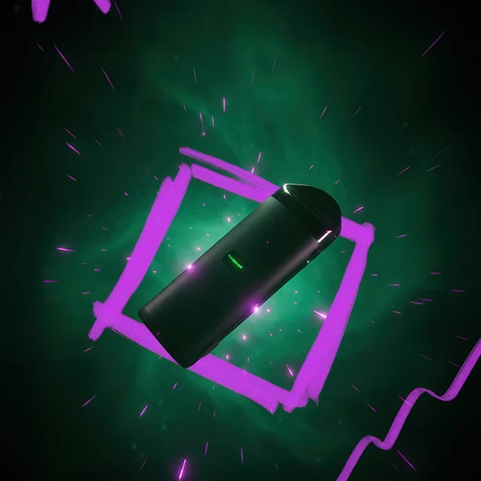 Angled top-down view of the Cloudious 9 Atomic9 Dry Herb Vaporizer floating over a glowing green background framed by neon pink brushstroke lines.