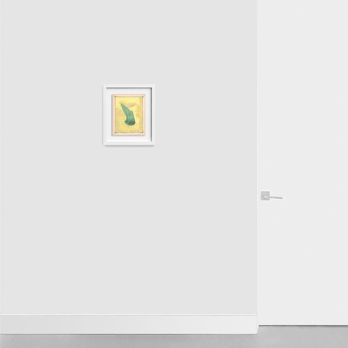 A small framed print with a teal organic shape on a yellow background hanging on a light gray wall next to a white door