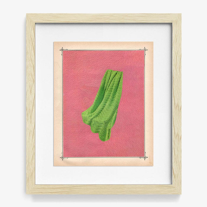 Framed print Color Play 132 with a light wood frame showing green fabric on a pink background with a decorative border