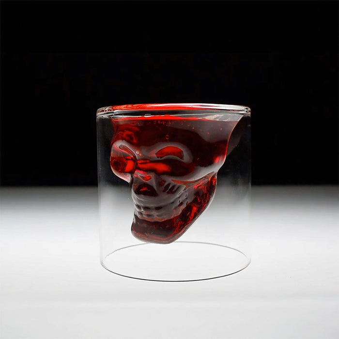 Glass with a skull design filled with red liquid on a black and white background
