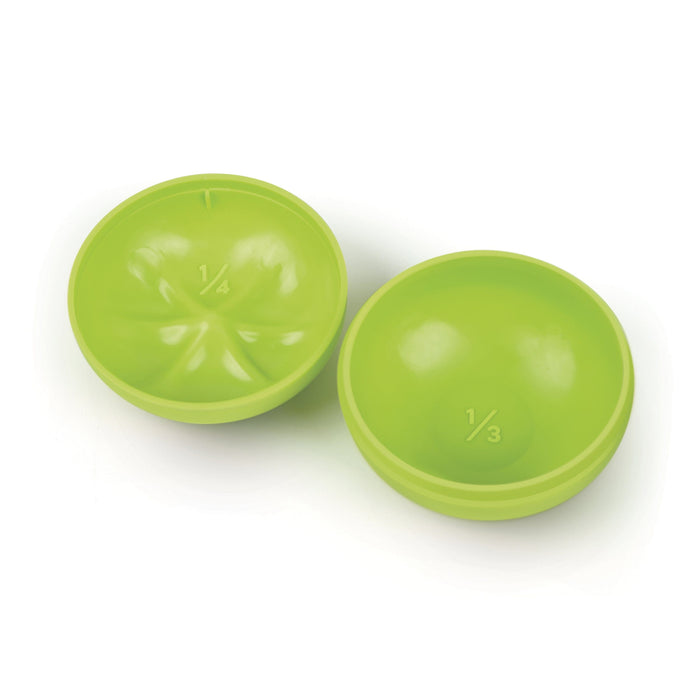 Interior of two green tomato measuring cups on a white background