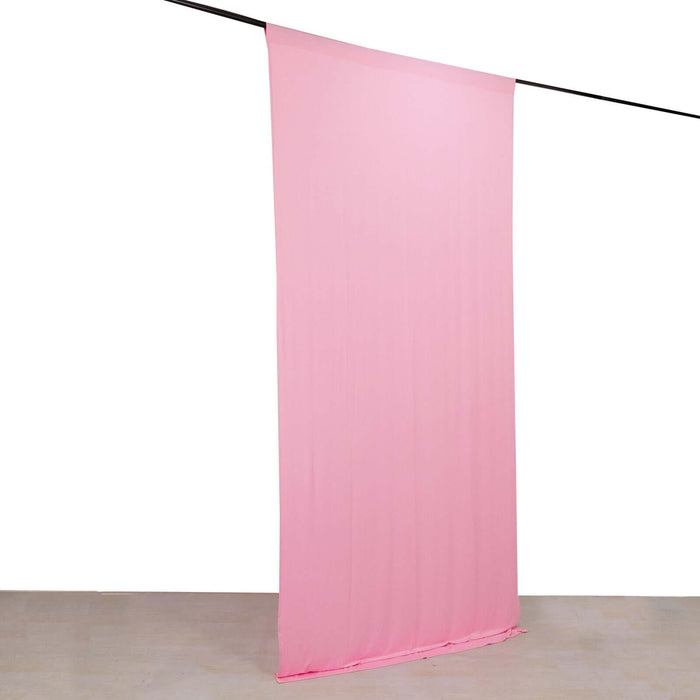 Pink fabric backdrop hanging on a rod.