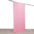 Pink fabric backdrop hanging on a rod.