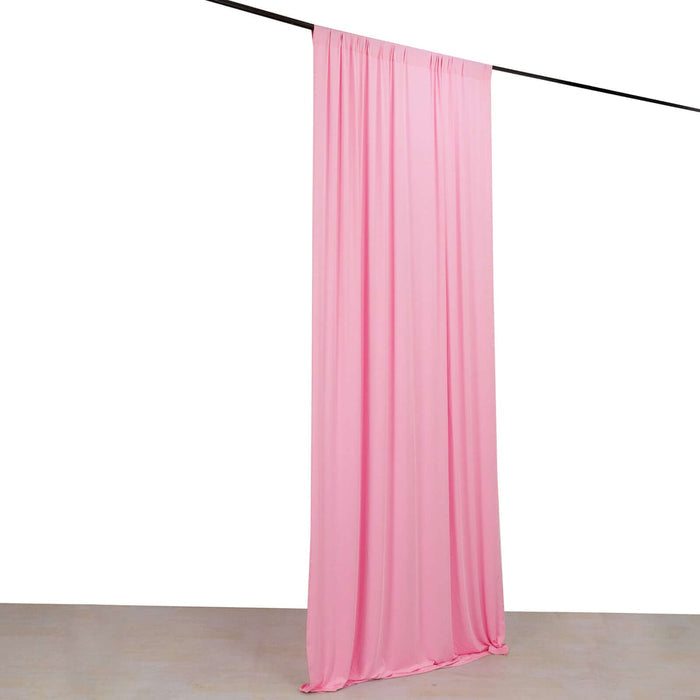 Pink fabric backdrop hanging from a rod in a studio setting