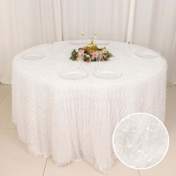 White textured tablecloth draped over a round table with floral centerpiece.