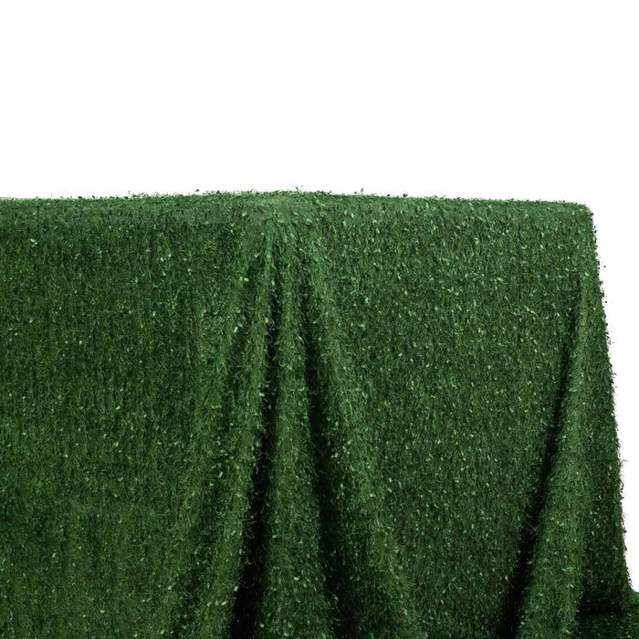 Green artificial grass tablecloth on a plain backdrop.