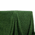 Green artificial grass tablecloth on a plain backdrop.