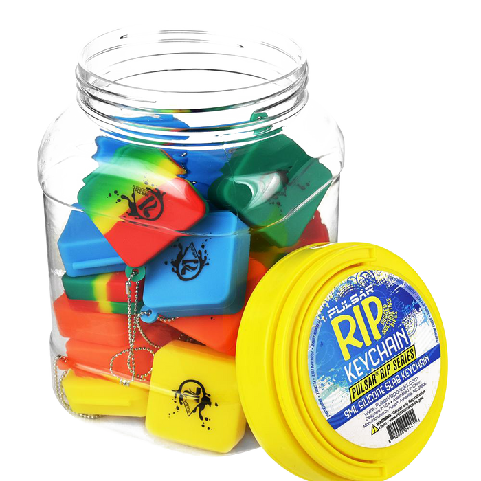 A bulk assortment of colorful Pulsar Silicone Dab Slab Containers is displayed in a top-down view, highlighting the vibrant mix of colors and simple shapes.