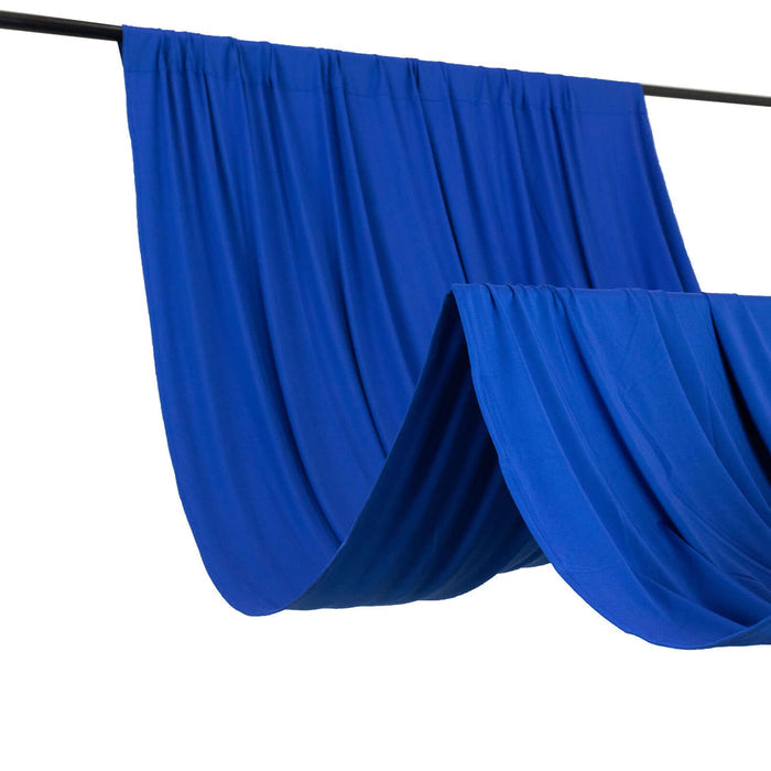 Blue fabric drapes hanging on a rod against a plain backdrop.