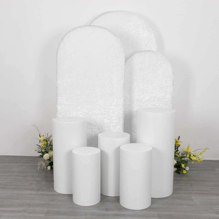 White display pedestals in various heights with floral accents.