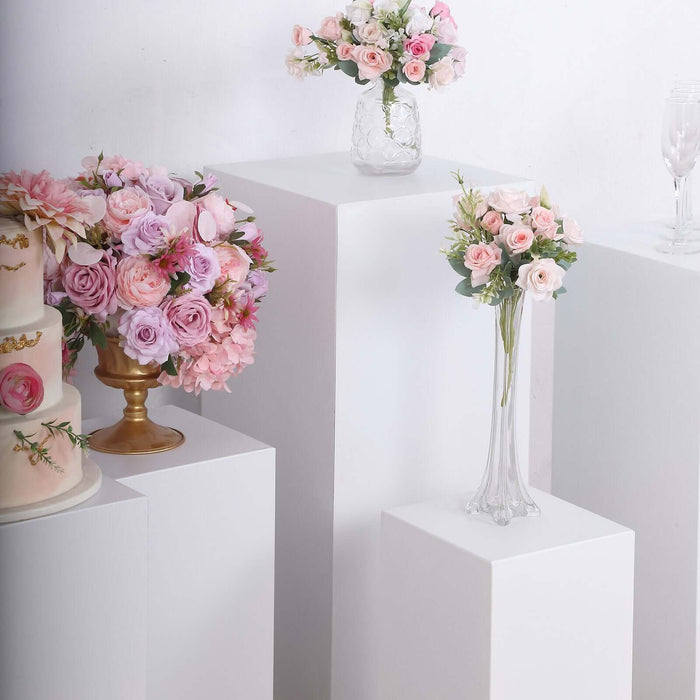 Elegant floral arrangements in various vases displayed on white pedestals.