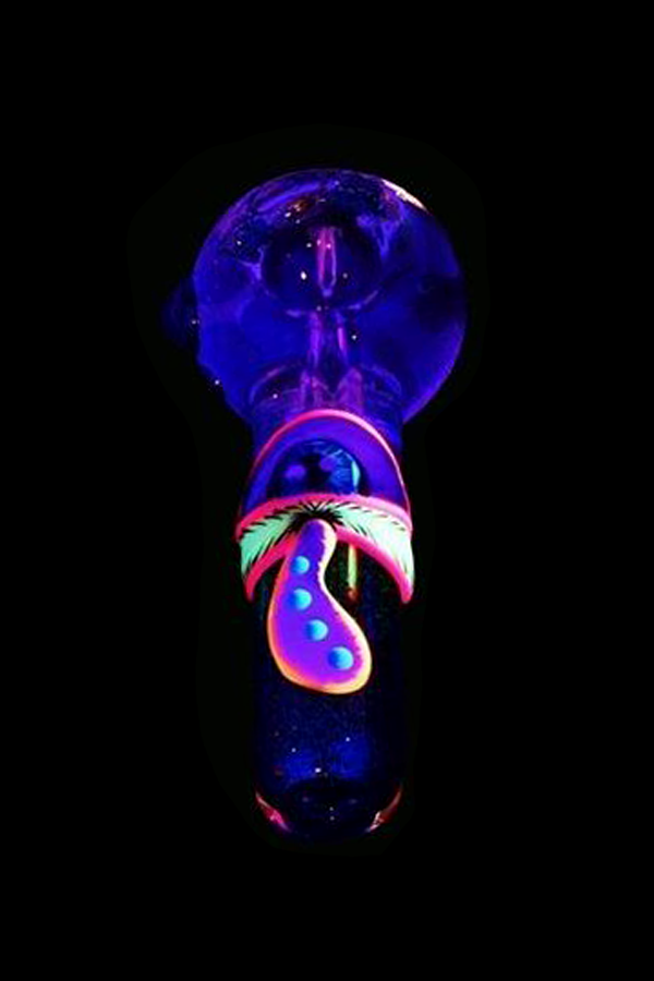 Glow-in-the-dark glass pipe shaped like a mushroom against a black background.