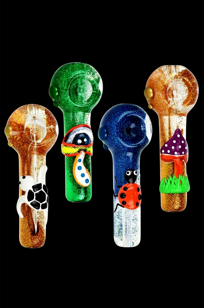 Four colorful glass smoking pipes decorated with whimsical designs – a skull, an eye, a ladybug, and mushrooms – against a black background.