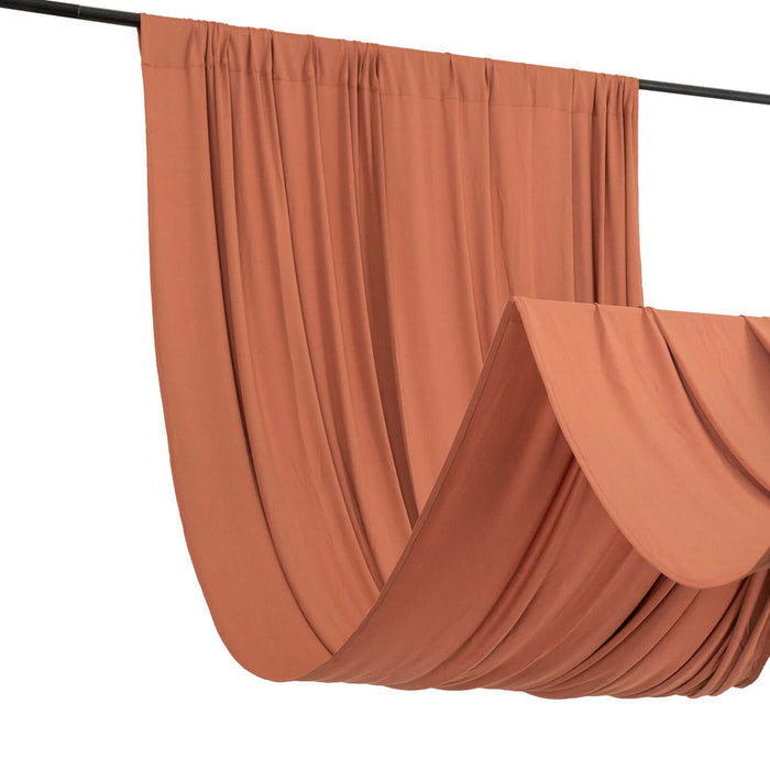 Rust-colored fabric draped elegantly on a rod, showcasing its soft texture.