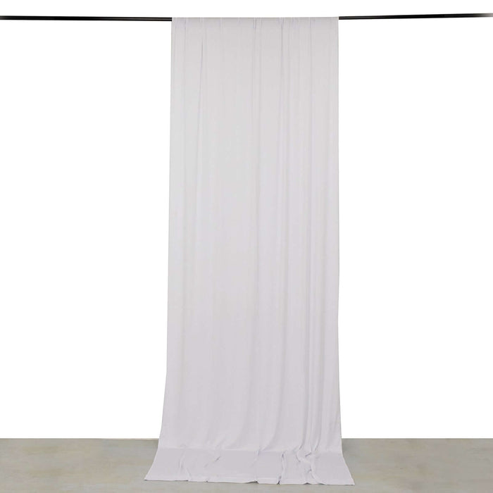 White fabric drape hanging from a rod in a studio setting